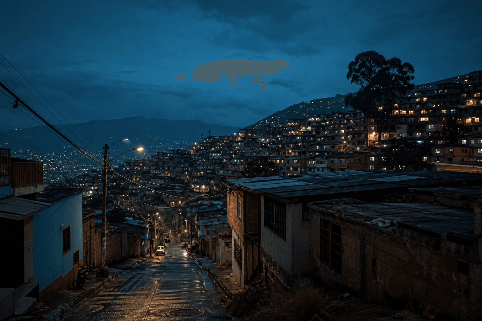 Barrio de ladera en Medellín al anochecer, con las luces de las casas encendidas